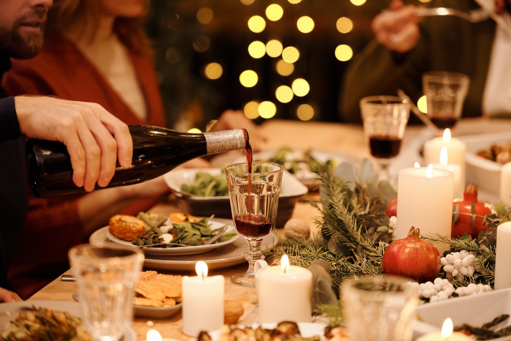 christmas themed table with wine being poured into a glass